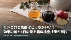 リンゴ酢と黒酢を並べたガラスのピッチャーとりんご