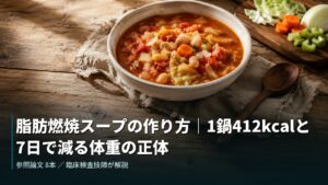 木のテーブルに置かれた野菜たっぷりのトマトスープと、キャベツ・にんじん・セロリ・たまねぎ