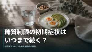 木のテーブルに置かれた水のグラス、ゆで卵とアボカドの皿、ナッツの小鉢